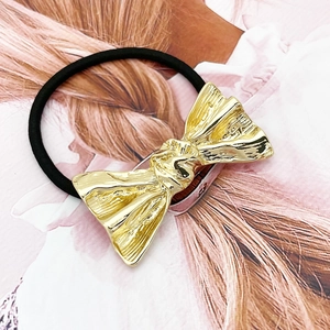 Minimalist golden alloy bow hair tie with textured finish and black elastic band for women