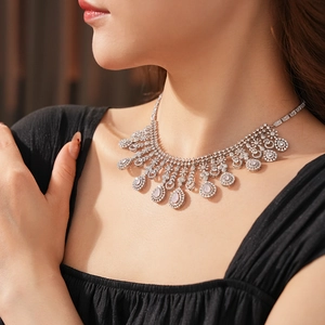 Close-up of a silver necklace with sparkling pink zircon teardrop pendant on a model