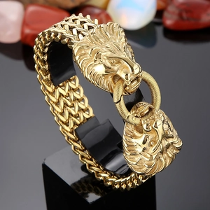 Close-up of golden lion head curb chain bracelet with detailed metal engraving and shiny finish