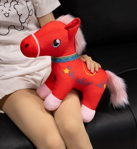 Close-up of red plush horse toy with floral embroidery and pink mane detail