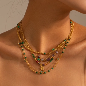 Detail of layered 18K gold plated necklace with turquoise beads and sun pendant charms