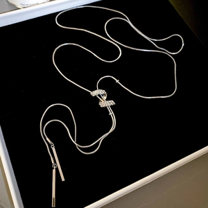 Macro detail of silver adjustable Y-necklace with crystal slider on black velvet