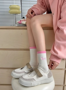 Close-up of white cotton socks with pink ribbed cuffs and Bunny embroidery detail