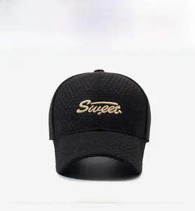 Détail de la casquette noire texturée avec broderie dorée Sweet sur le devant du tissu