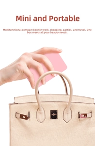 Compact pink portable LED makeup mirror storage box being placed into a luxury beige handbag
