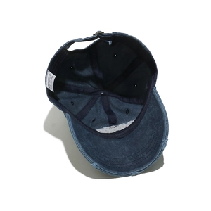 Macro shot of 100% cotton wash label and distressed brim on vintage navy baseball cap