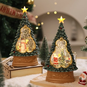 Close-up of lighted Christmas tree water globe with Santa Claus and snowman miniatures