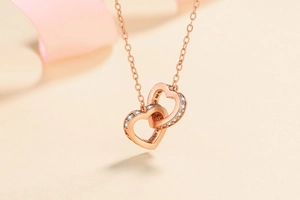 Gros plan du pendentif double cœur en or rose serti de moissanites étincelantes