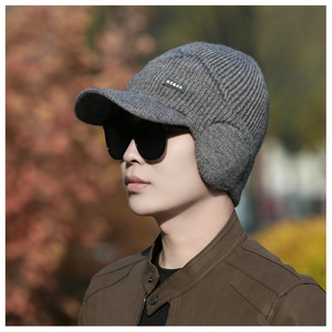 Detail of grey winter knit hat for men with ear flaps, visor and NY&JA side label