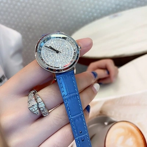Detail of silver ladies watch with crystal dial and blue leather strap on wrist