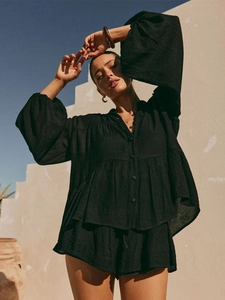 Detailed texture of black long sleeve button shirt and shorts in a breezy resort style