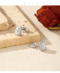 Detailed view of emerald cut moissanite earrings with S925 hallmark on a textured surface