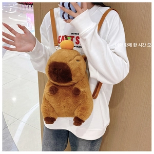 Detail view of a cute plush Capybara backpack with orange fruit decor on a model