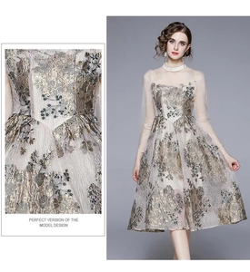 Details der edlen Goldstickerei und Netzärmel an einem französischen Midi-Kleid