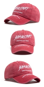 Detail of red washed cotton baseball cap featuring white 3D letter embroidery accents