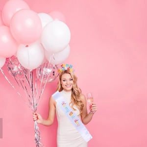 Detail of white satin sash and colorful headband with It's my Birthday text for party