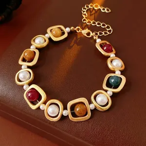 Vintage style gold bracelet with geometric charms and pearls on leather display