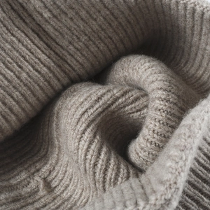 Thick taupe ribbed knit beanie made of warm wool, showing soft texture and premium quality