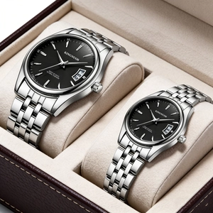Close-up of couple watches with black dials in a premium brown leather gift box