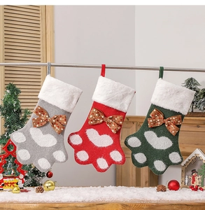 Trois chaussettes de Noël en tricot patte de chien rouge, gris et vert suspendues