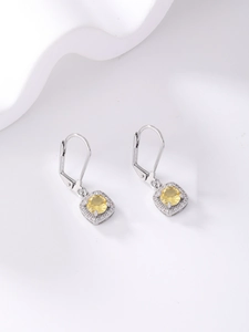 Macro view of silver leverback earrings featuring round yellow zircon and halo crystals