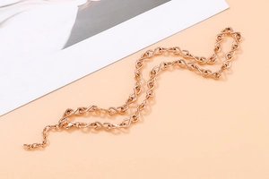 Dettaglio della collana con maglie a infinito in oro rosa e chiusura a moschettone