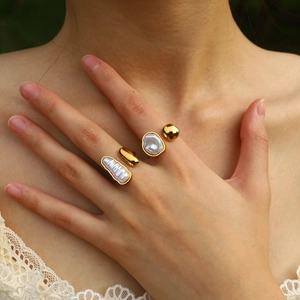 Adjustable gold irregular ring set with baroque pearls on model's hand with white lace