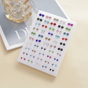 Macro shot of 50 pairs colorful rhinestone stud earrings set on a white display card