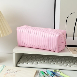 Close-up of pink quilted faux leather pencil case on a clean minimalist desk setup