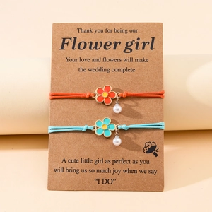 Detail view of flower enamel charm bracelets with pearls and flower girl thank you card