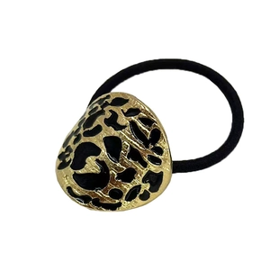 Close-up of golden irregular metal hair tie with black leopard print pattern details