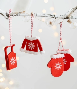 Close-up of red wooden Christmas ornaments with snowflake patterns on snowy branches