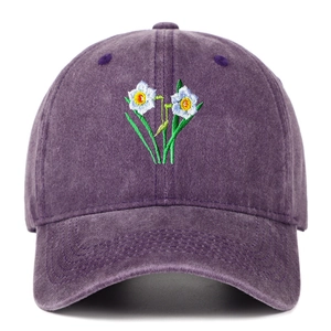 Close-up of daffodil embroidery on washed purple cotton baseball cap with vintage finish