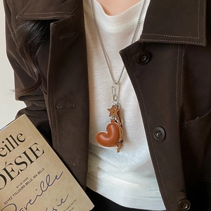 Close-up of vintage heart leather pendant necklace with star charms on a model
