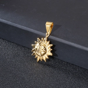 Détail d'un pendentif soleil doré posé sur une surface noire texturée élégante