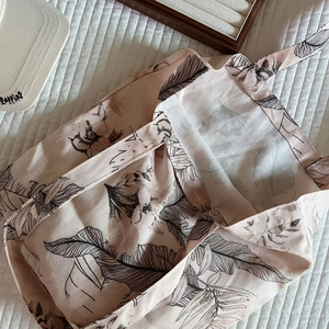 Detailed texture of linen canvas tote bag with elegant dark botanical leaf patterns