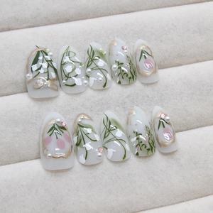 Press-on nails with pink tulips, white lily designs, pearls and rhinestones on milky base