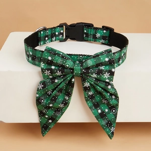 Detail of green plaid dog collar with snowflake patterns and metal D-ring buckle