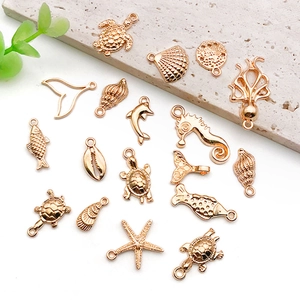 Flache Ansicht goldener Meeres-DIY-Anhänger mit Schildkröten Muscheln und Seesternen