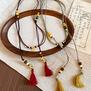 Detailed close-up of handmade wooden beads and silk tassels on Neo-Chinese waist chains