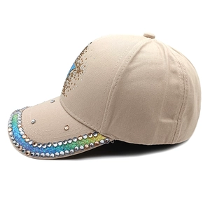 Detail of beige cotton baseball cap with multi-color rhinestones on the brim and crown