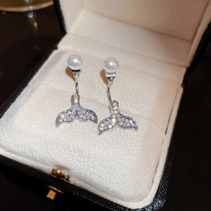 Macro view of silver whale tail earrings with colorful rhinestones and white pearls