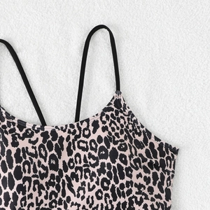 Detailaufnahme des Bikini-Oberteils mit Leopardenmuster und schwarzen Trägern auf Kunstfell