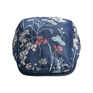 Detailed close-up of blue denim newsboy cap with white and pink floral print textures