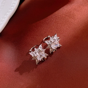 Sparkling zircon flower star ear cuffs with silver plating on elegant red silk fabric