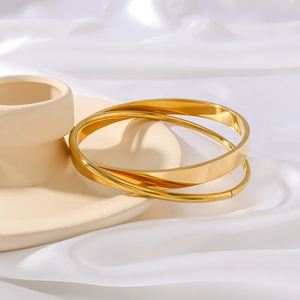 Minimalist gold triple-layer interlocking bangle in polished finish on a white stand