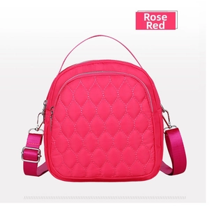 Close-up of rose red waterproof nylon bag with leaf quilting and dual zipper detail