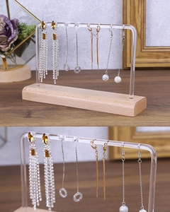 Detail of wooden earring stand with acrylic U-frame and multi-hole display for studs