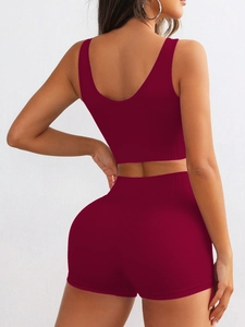 Women's burgundy ribbed knit seamless yoga set featuring crop tank top and high waist shorts