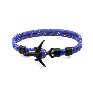Detail of blue braided parachute cord bracelet with a black airplane charm and buckle